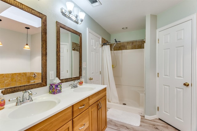 bathroom with double vanity, visible vents, a sink, and a shower with shower curtain