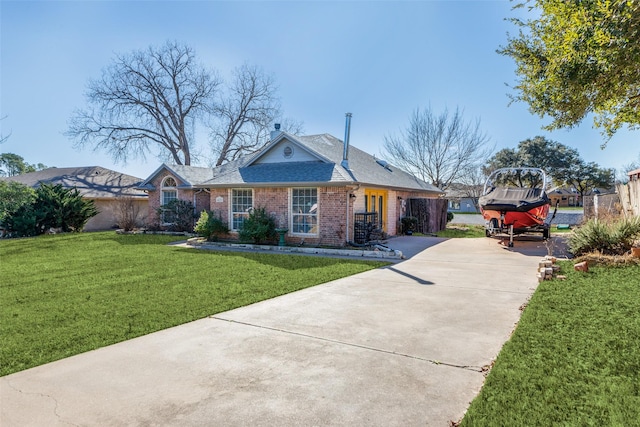 view of front of property featuring a front yard, brick siding, a chimney, and roof with shingles