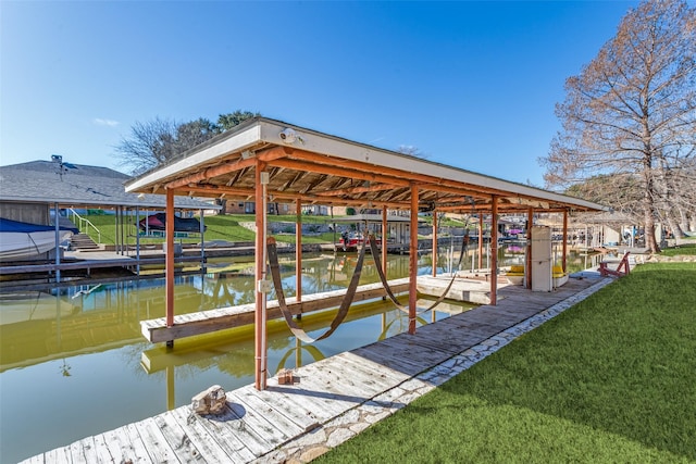 dock area featuring a water view, a lawn, and boat lift