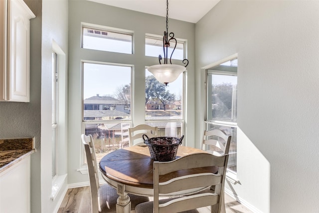 dining area featuring light wood-style flooring and baseboards