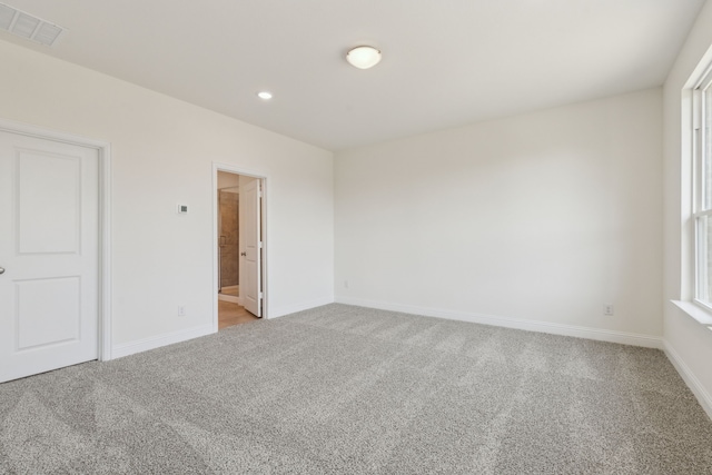 spare room featuring recessed lighting, visible vents, light carpet, and baseboards