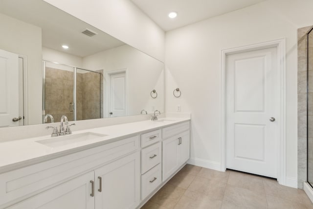 bathroom with double vanity, a stall shower, and a sink