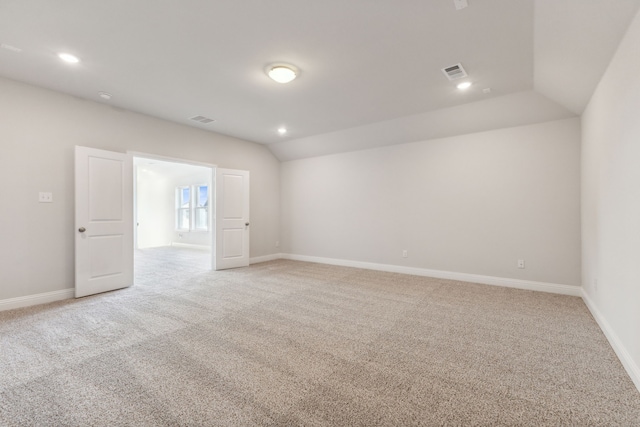 empty room with lofted ceiling, baseboards, light colored carpet, and recessed lighting