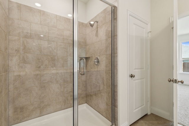 full bathroom with baseboards and a stall shower