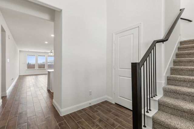 staircase featuring baseboards and wood tiled floor