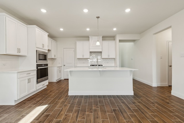 kitchen featuring decorative backsplash, stainless steel microwave, dark wood-type flooring, and oven
