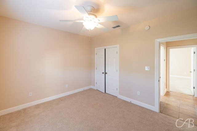 unfurnished bedroom with carpet, a closet, visible vents, and baseboards