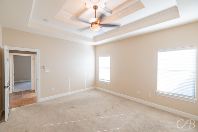 carpeted empty room with baseboards, a raised ceiling, a ceiling fan, and crown molding