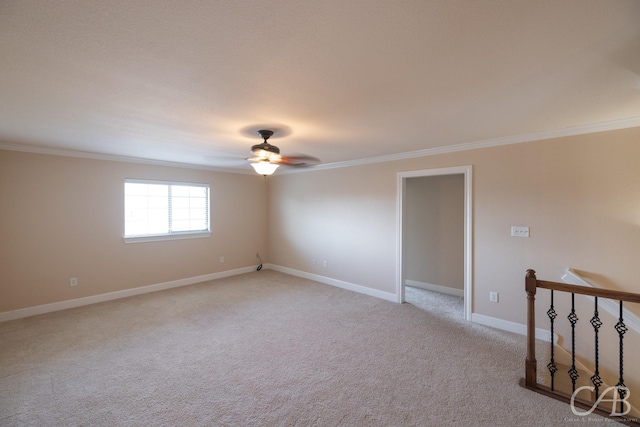 unfurnished room featuring baseboards, ornamental molding, a ceiling fan, and light colored carpet