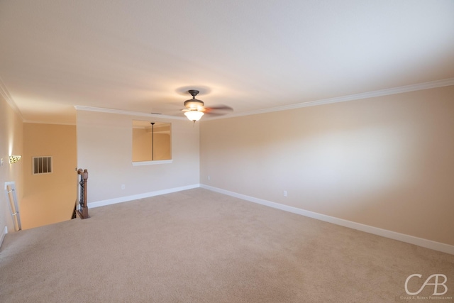 empty room with light carpet, a ceiling fan, visible vents, baseboards, and ornamental molding