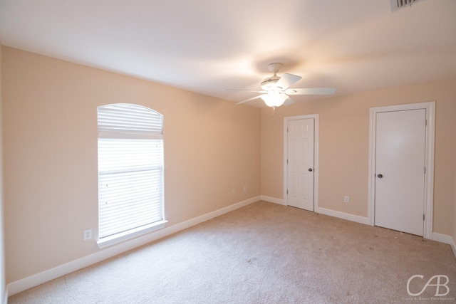 unfurnished bedroom featuring two closets, carpet, baseboards, and a ceiling fan