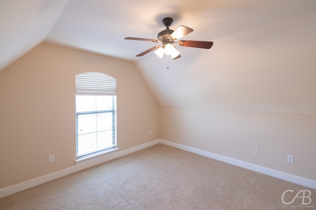 additional living space featuring vaulted ceiling, carpet flooring, a ceiling fan, and baseboards