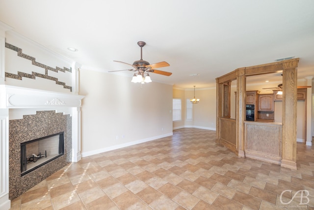 unfurnished living room with crown molding, visible vents, a fireplace, and ceiling fan with notable chandelier