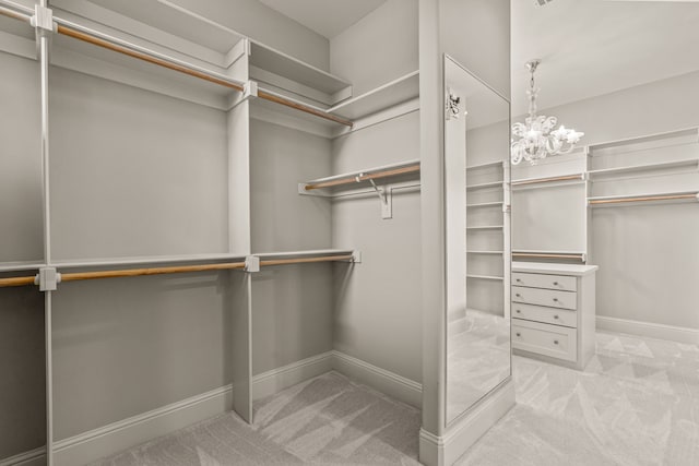 spacious closet featuring carpet floors and a notable chandelier