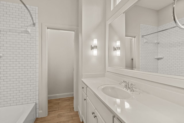 full bathroom with wood finished floors, vanity, and baseboards