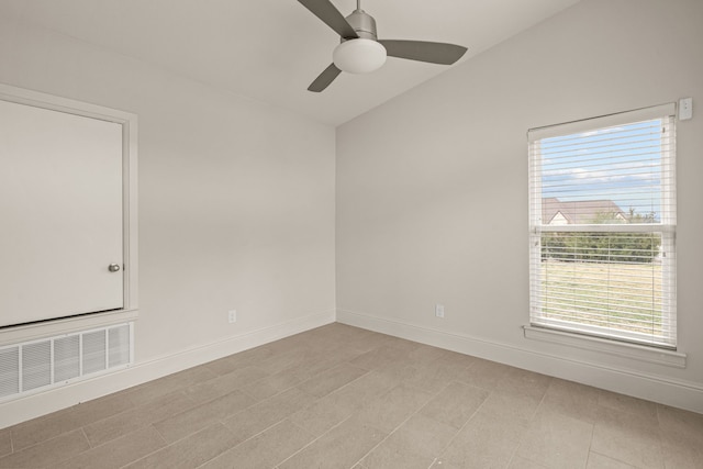 empty room with baseboards, visible vents, vaulted ceiling, and a ceiling fan