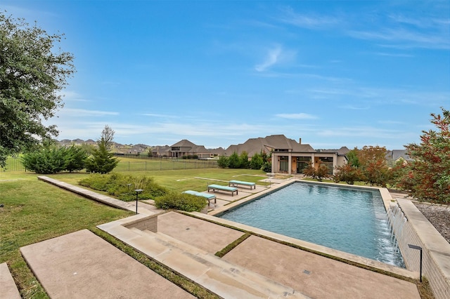 outdoor pool featuring fence, a patio, and a yard