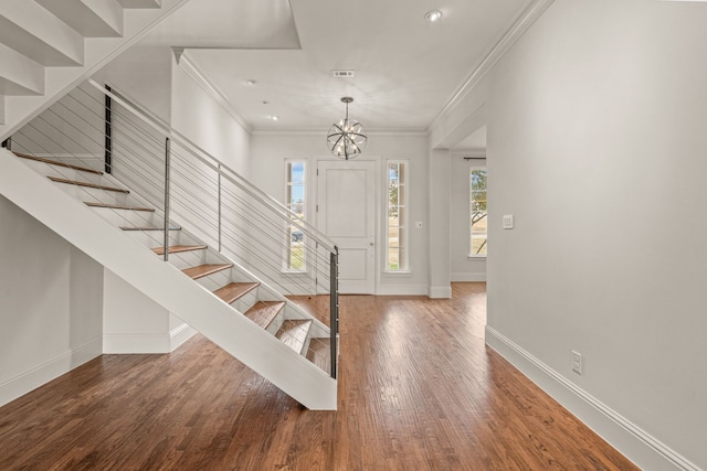 foyer with a chandelier, baseboards, stairs, wood-type flooring, and crown molding