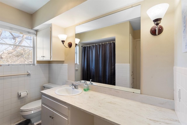 bathroom featuring toilet, a wainscoted wall, tile walls, and vanity