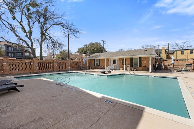 pool featuring fence, an outdoor structure, and a patio