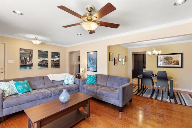 living room featuring recessed lighting, ceiling fan with notable chandelier, baseboards, ornamental molding, and light wood finished floors