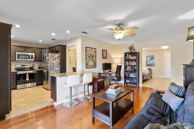 living area featuring recessed lighting, visible vents, ceiling fan, light wood-type flooring, and baseboards