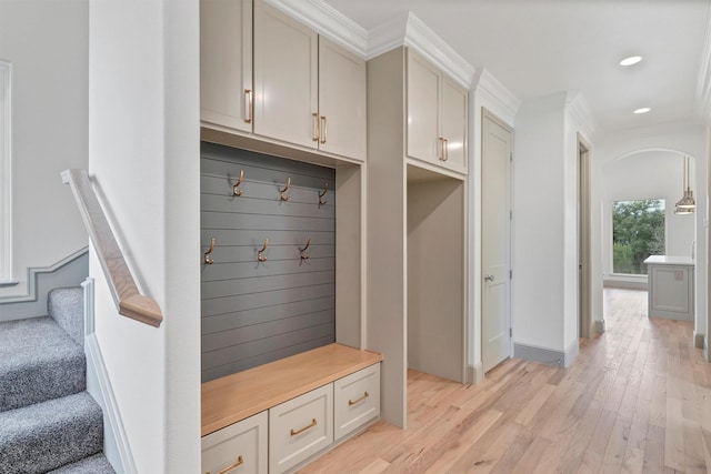 mudroom with arched walkways, recessed lighting, baseboards, light wood-type flooring, and crown molding