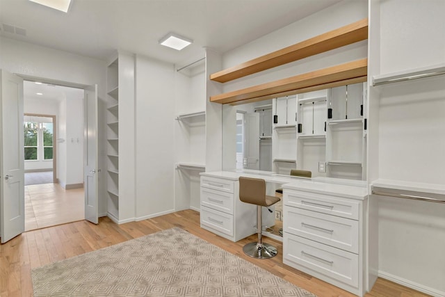 unfurnished office featuring baseboards, visible vents, and light wood-style floors