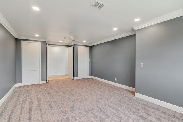 unfurnished room with light colored carpet, visible vents, and crown molding