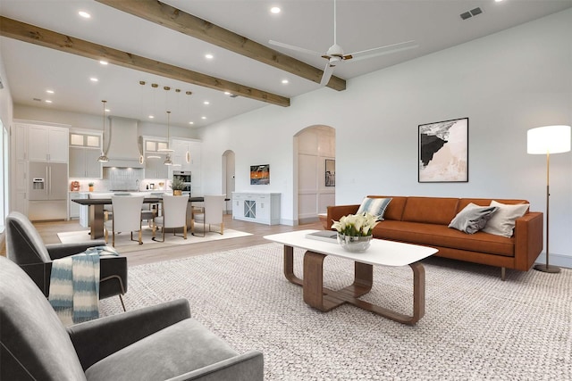 living area with visible vents, arched walkways, beam ceiling, and recessed lighting