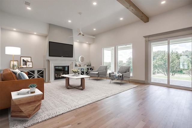 living room featuring recessed lighting, wood finished floors, visible vents, beamed ceiling, and a glass covered fireplace