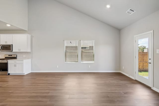 interior space featuring baseboards, visible vents, and wood finished floors