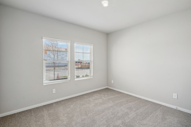 empty room with carpet and baseboards