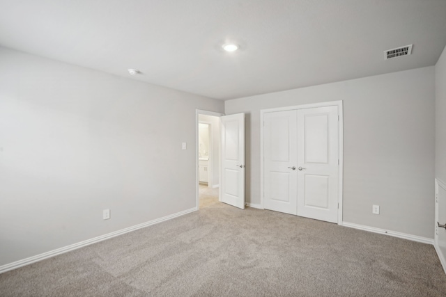 unfurnished bedroom with carpet, a closet, visible vents, and baseboards