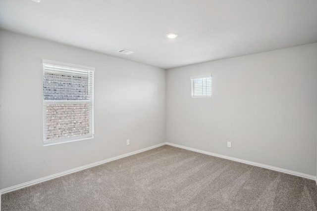 carpeted spare room with baseboards and visible vents