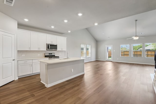 kitchen featuring open floor plan, stainless steel appliances, visible vents, and white cabinetry