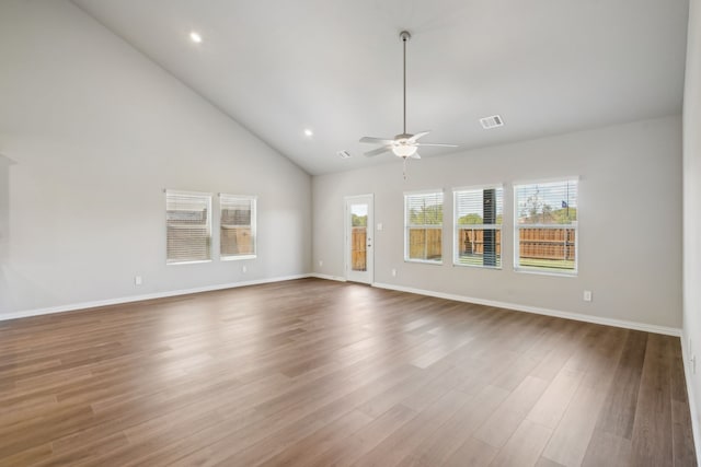 unfurnished room with ceiling fan, high vaulted ceiling, wood finished floors, visible vents, and baseboards