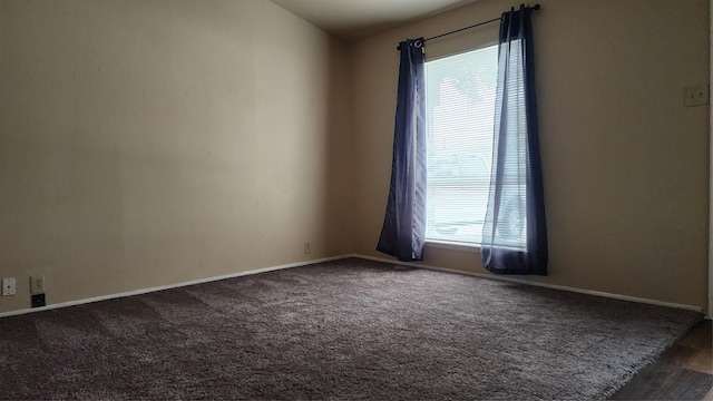 carpeted empty room featuring a wealth of natural light and baseboards