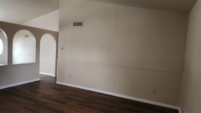 437 W Grenoble Dr, Grand Prairie, TX 75052 - empty room with a wainscoted wall, vaulted ceiling, dark wood finished floors, and visible vents