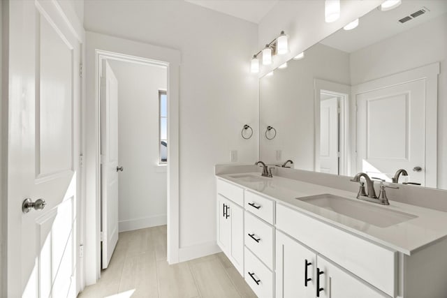 bathroom featuring double vanity, baseboards, visible vents, and a sink