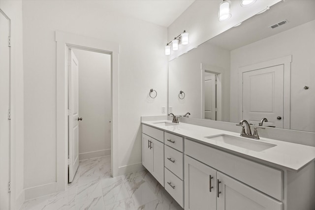 bathroom featuring marble finish floor, baseboards, visible vents, and a sink