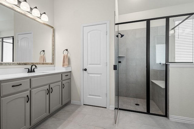 bathroom featuring baseboards, a shower stall, and vanity