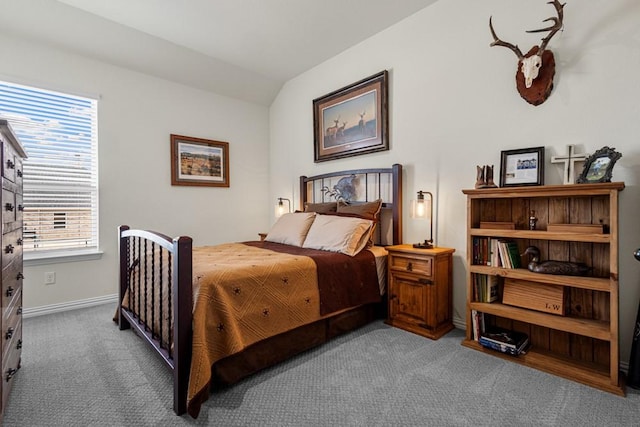 carpeted bedroom with lofted ceiling and baseboards