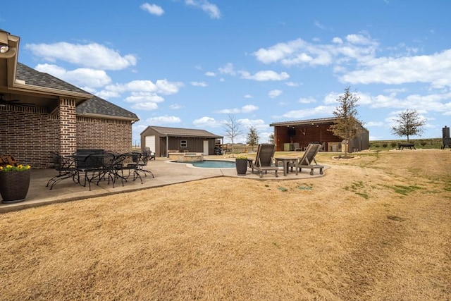 view of yard with a patio area, an outdoor structure, and an outdoor pool