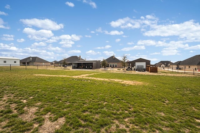 view of yard featuring a garage, an outbuilding, and fence