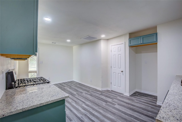 kitchen featuring baseboards, visible vents, light wood finished floors, recessed lighting, and range with gas cooktop