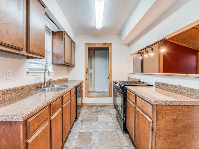 kitchen featuring stone finish flooring, a sink, baseboards, brown cabinets, and black appliances