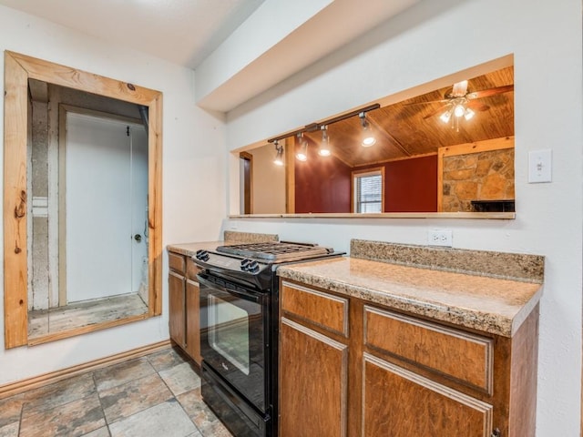 kitchen with brown cabinetry, wood ceiling, light countertops, and black range with gas stovetop