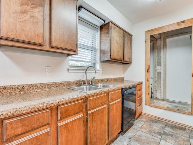 kitchen featuring brown cabinets, black dishwasher, light countertops, and a sink