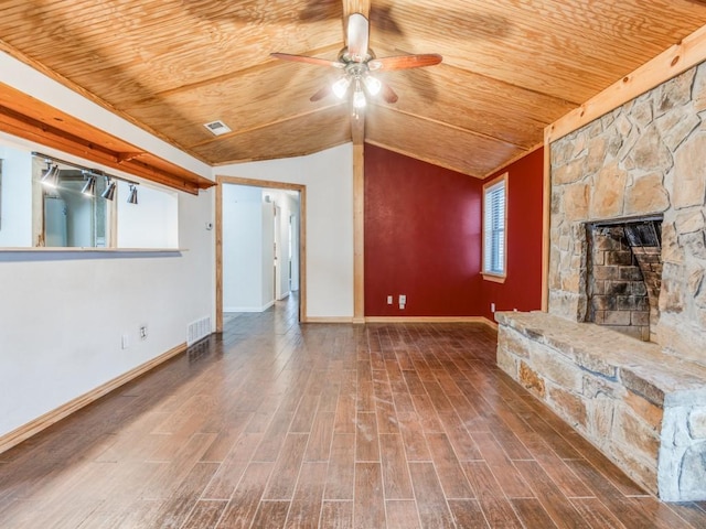 unfurnished living room with visible vents, wooden ceiling, wood finished floors, vaulted ceiling, and a stone fireplace